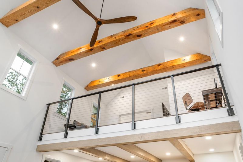Timber beams and the loft railing, seen from the great room below