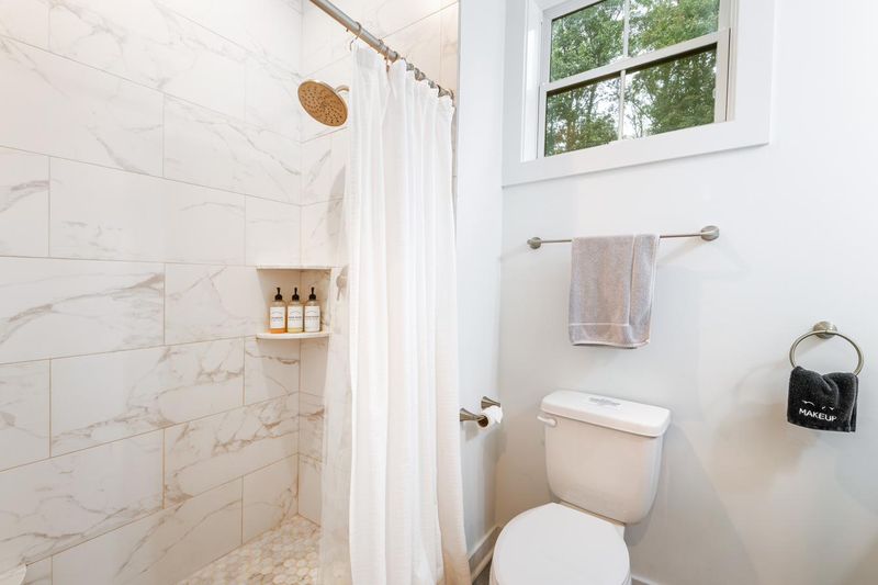 The primary bathroom, with a tiled walk in shower